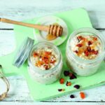 Due vasetti di overnight oats con yogurt, albicocche e mirtilli rossi secchi
