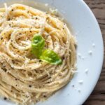 Pasta cremosa al parmigiano e pepe con basilico decorativo